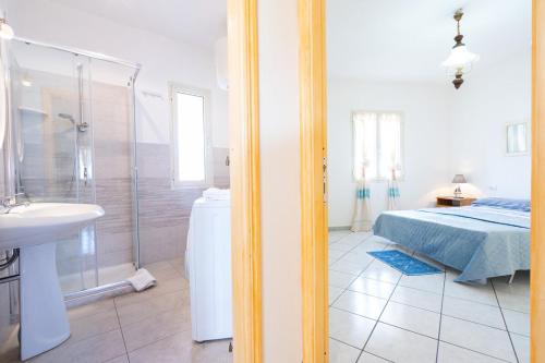 a bathroom with a bed and a shower and a sink at Casa Rockefeller in San Teodoro