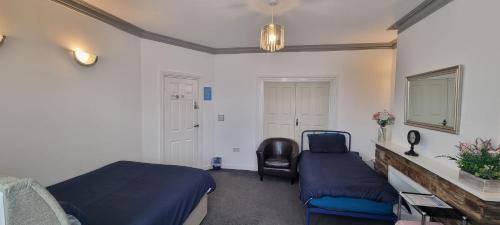 Un dormitorio con 2 camas y una silla. en Plymouth Airbnb en Plymouth