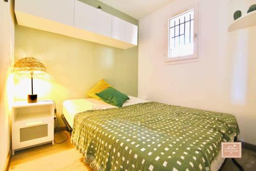 Un dormitorio pequeño con una cama y una lámpara. en L’alyzarine, en La Seyne-sur-Mer