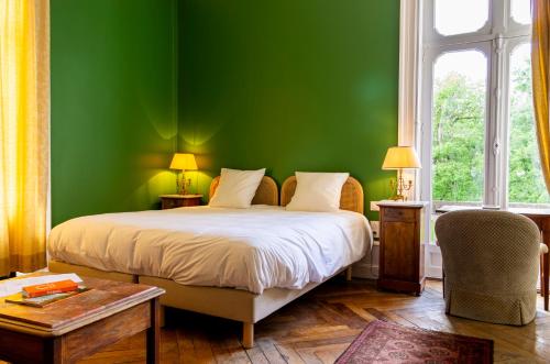 Dormitorio verde con cama y ventana en Château De L'aubrière - Teritoria, en Tours