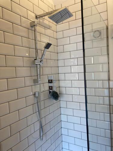 a shower in a bathroom with white tiles at The Stables, Modern 2 bed, 4 person, Rural Barn Conversion with Great Access in Silkstone