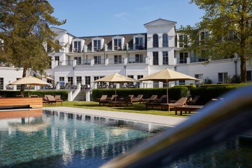 a hotel with a swimming pool in front of a building at Strandhotel Zingst in Zingst