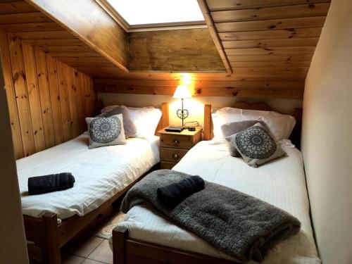 - une chambre avec 2 lits dans une cabane en bois dans l'établissement Stunning Mountain Village Apartment Fabulous Views, aux Contamines-Montjoie
