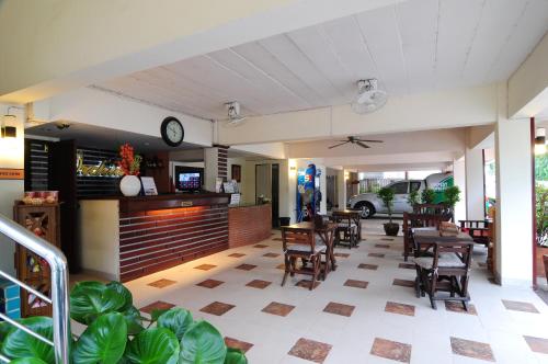 ein Restaurant mit Tischen und Stühlen und einer Uhr an der Wand in der Unterkunft Khon Kaen Orchid Hotel in Khon Kaen