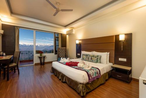a bedroom with a large bed with a large window at Grand View Hotel in Dalhousie