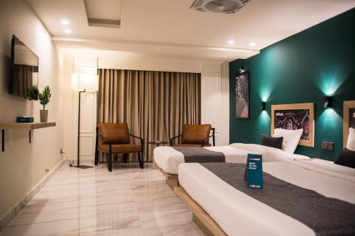 duas camas num quarto de hotel com paredes verdes em LOKAL Rooms x Murree Valley View em Murree