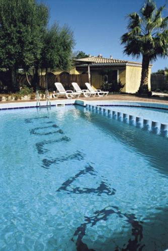 a swimming pool with a sign in the water at Hotel L'Ulivo in Girasole