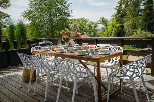 a wooden table and chairs on a deck at Lake house with sun terrace for 8 guests in Herrsching am Ammersee