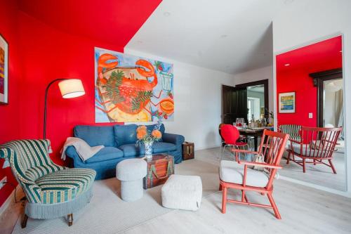 a living room with a blue couch and red walls at Lake house with sun terrace for 8 guests in Herrsching am Ammersee
