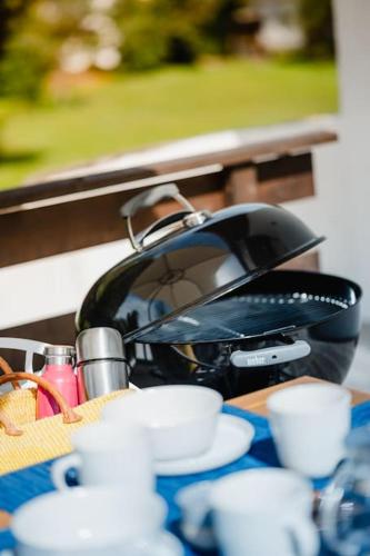 a tea kettle and cups sitting on a table at Lake house with sun terrace for 8 guests in Herrsching am Ammersee