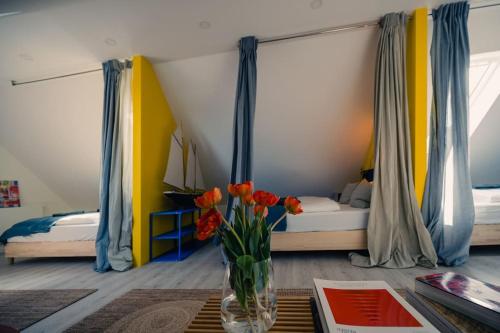 a bedroom with a bed and a vase of flowers on a table at Lake house with sun terrace for 8 guests in Herrsching am Ammersee