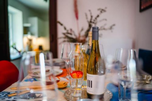 a bottle of wine sitting on a table with glasses at Lake house with sun terrace for 8 guests in Herrsching am Ammersee