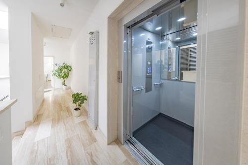 a bathroom with a shower with a glass door at Bcolors Rooms, Selargius Is Corrias in Pirri