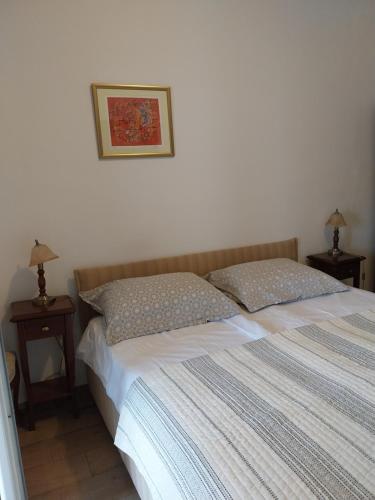 a bedroom with a bed with two nightstands and two lamps at Apartment Perica in Dubrovnik