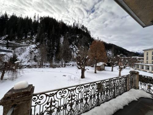a view of a snow covered yard with a fence at Scuol Palace - Culture, Nature & Health in Scuol