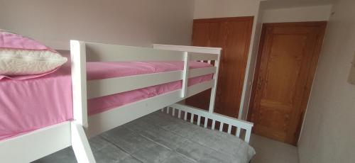 a bedroom with two bunk beds with pink sheets at Barlovento H in Xeraco