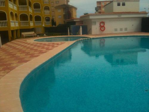 a large blue swimming pool in front of a building at Barlovento H in Xeraco