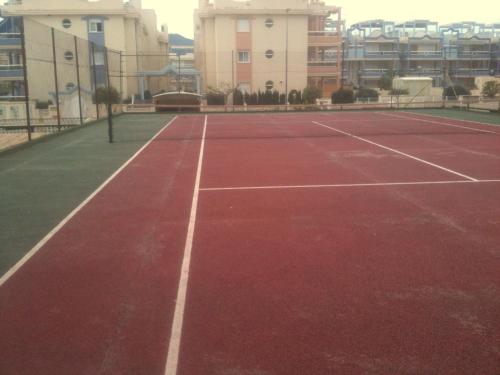 a tennis court in front of some buildings at Barlovento H in Xeraco