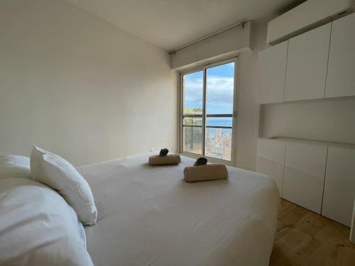 une chambre blanche avec un grand lit avec une fenêtre dans l'établissement Bellavista, à Beausoleil