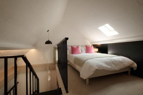 a bedroom with a large bed with pink pillows at The Old Stables in Newcastle upon Tyne