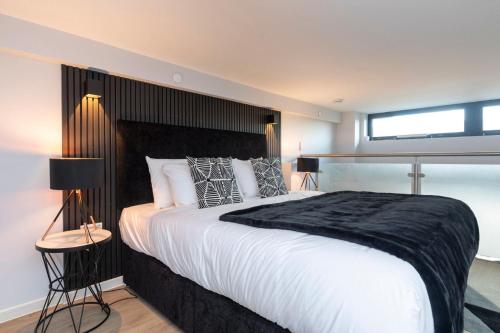 um quarto com uma cama grande e uma cabeceira preta em Palm Tree House - Angles Max em Orpington