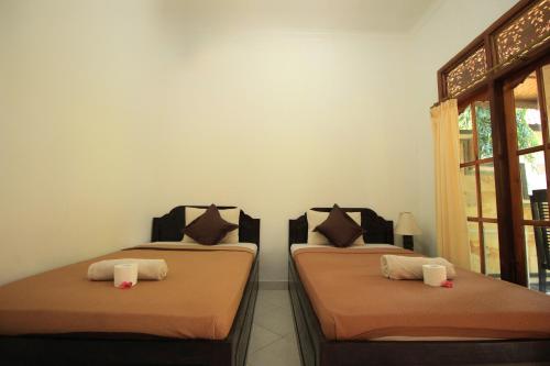 two beds sitting next to each other in a room at Jepun Bali Bungalow in Nusa Lembongan