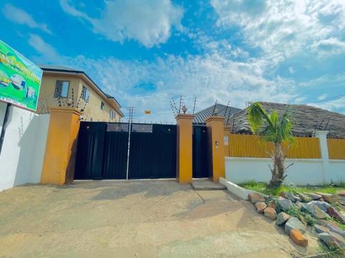 una casa con una valla azul y amarilla en Nana's Holiday Let en Accra