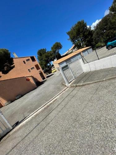 une rue vide avec une clôture et un bâtiment dans l'établissement appartement bord de mer Martigues, à Martigues