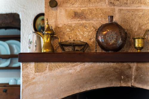 a mantle with a clock and other items on it at Ilianthos Traditional Maisonette in Hersonissos