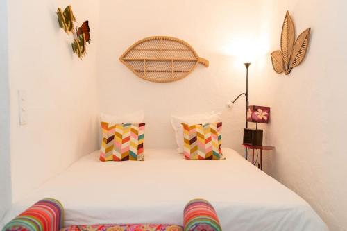 - une chambre avec un lit blanc et des oreillers colorés dans l'établissement 30m2 climatisés dans le village, à Saint-Tropez