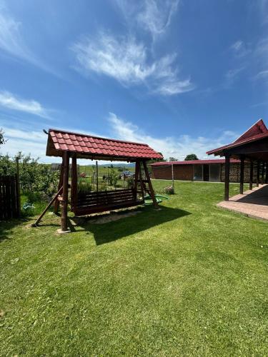 a park with a pavilion in a grass field at Casa de la Baltă in Rieni