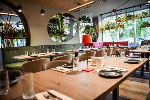 a restaurant with wooden tables and chairs and windows at Exclusive Hotel & More in Sibiu