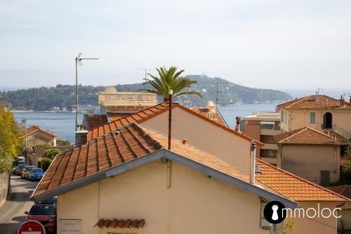 un bâtiment avec un palmier au sommet dans l'établissement Maison climatisée avec vue mer, à Villefranche-sur-Mer
