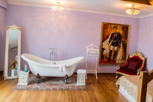 uma casa de banho com banheira e uma pintura na parede em Landhotel Beverland bei Münster em Ostbevern