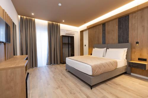a bedroom with a large bed and a television at Hotel Joni Premium in Ksamil
