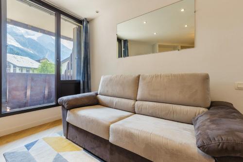 un salon avec un canapé et une grande fenêtre dans l'établissement Chamonix Sud - Lognan 106 - Happy Rentals, à Chamonix-Mont-Blanc