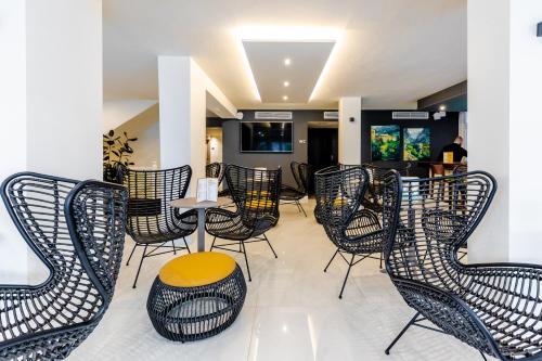 a restaurant with black chairs and a table with a yellow stool at Cabot Playa Grande - Adults Only in Playa de Palma