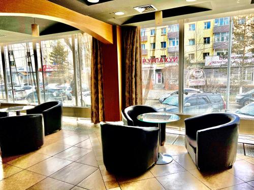 a restaurant with chairs and a table and a window at Kharaa Hotel & Restaurant in Ulaanbaatar