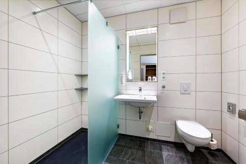 a bathroom with a toilet and a sink at INSIDE Hotel Nordhorn in Nordhorn