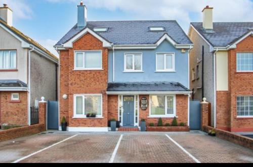 ein Haus mit blauer Tür auf einem Parkplatz in der Unterkunft Almara House in Galway