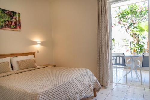 a bedroom with a bed and a window and a table at Missiria Apartments in Rethymno Town