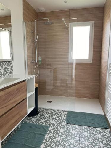 une salle de bain avec une douche avec une porte vitrée dans l'établissement La Maison des Copains au coeur du DDAY, à Carentan