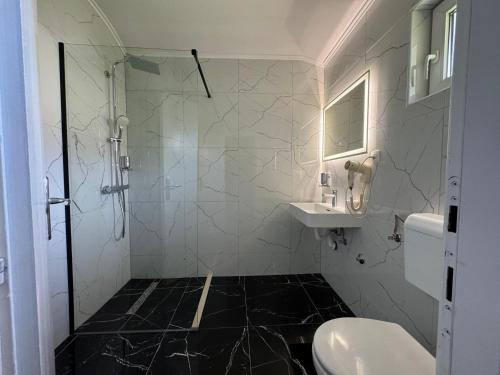 a bathroom with a shower and a toilet and a sink at Hotel Villa Nadin in Mostar