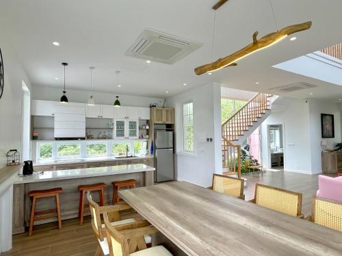 uma cozinha e sala de jantar com uma mesa de madeira e cadeiras em Lucia Villa - Melorita Hòa Lạc em Hanói