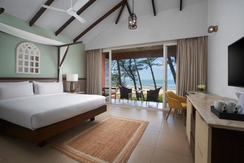 a bedroom with a bed and a view of the ocean at Mandrem Beach Resort, a member of Radisson Individuals Retreat in Mandrem
