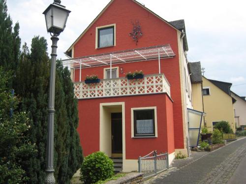 ブレムにあるComfortable Holiday Home near Vineyards in Bremmの赤い家 白いバルコニーと街灯