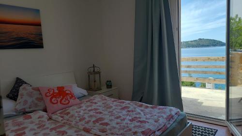 a bedroom with a bed with a view of the ocean at PomaloVilla at Gradina Cove in Vela Luka