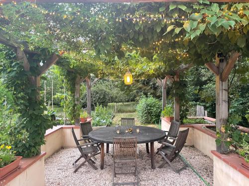 a patio with a table and chairs under a pergola at ChezLeMoulin Bed and Breakfast in Samouillan