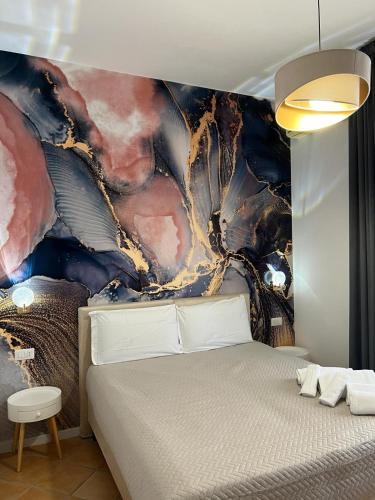 a bedroom with a bed with a painting on the wall at Le Corti del Re in Naples