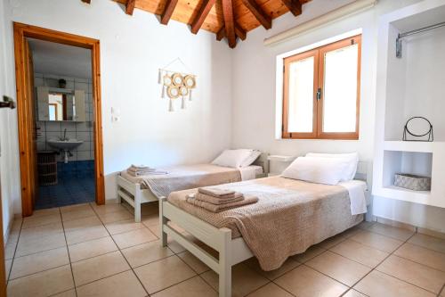 two beds in a white room with a bathroom at Villa Lazareta in Punta